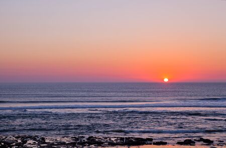 Sunset on Atlantic coast of Portugal at Praia da Areia Brancaの写真素材