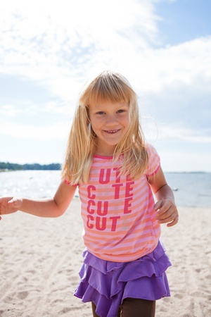 Cute happy young girl having fun at the beach in summerの写真素材