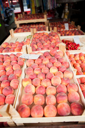 Fresh peaches in crates on sale at public weekend produce marketの写真素材