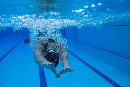 Female freediver with monofin swimming underwater in swimming poolの写真素材