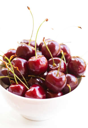 Closeup of bowl of fresh red cherries on light surfaceの写真素材
