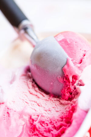 Closeup of raspberry ice cream and metal ice cream scoopの写真素材