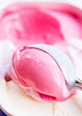 Closeup of raspberry ice cream and metal ice cream scoopの写真素材
