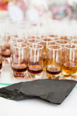 Closeup of glasses of fruity flavoured apertifs behind decorative stoneの写真素材