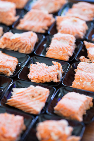Closeup of salmon appetizers on small serving trays in rowsの写真素材