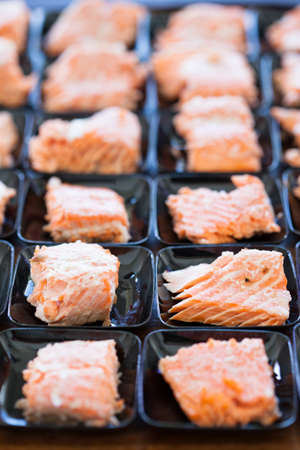 Closeup of salmon appetizers on small serving trays in rowsの写真素材