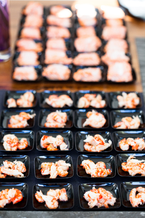 Closeup of shrimp appetizers on small serving trays in rowsの写真素材