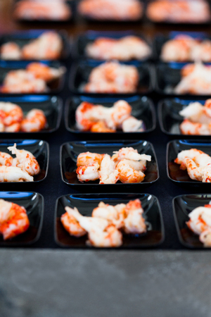 Closeup of shrimp appetizers on small serving trays in rowsの写真素材