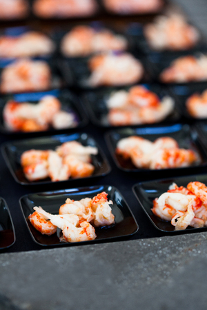 Closeup of shrimp appetizers on small serving trays in rowsの写真素材