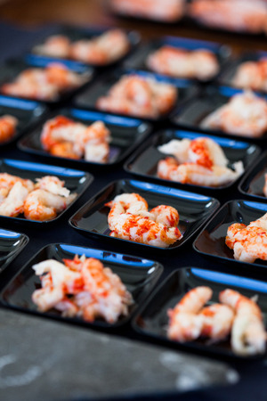 Closeup of shrimp appetizers on small serving trays in rowsの写真素材