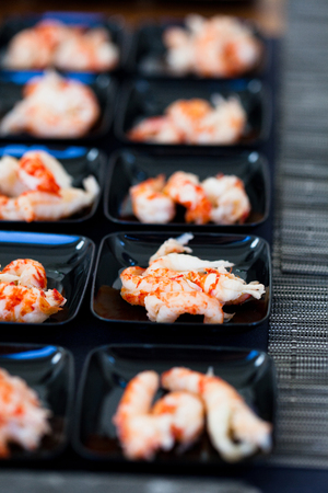 Closeup of shrimp appetizers on small serving trays in rowsの写真素材