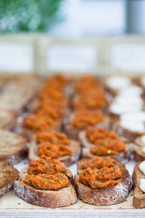 Closeup of bruschetta appetizers with savoury paste topping presented in rowsの写真素材