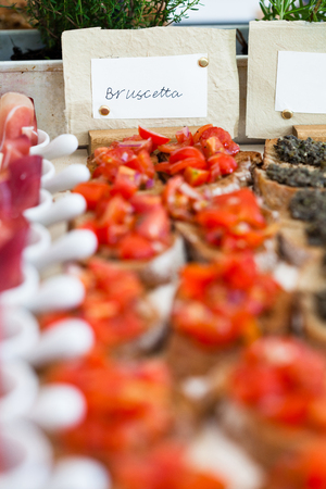 Closeup of bruschetta appetizers with tomato topping presented in rows and label with bruschetta textの写真素材