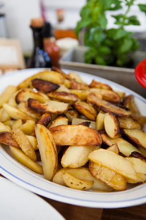 Closeup of plate of thick style french fries on table ready for serving at dinner partyの写真素材
