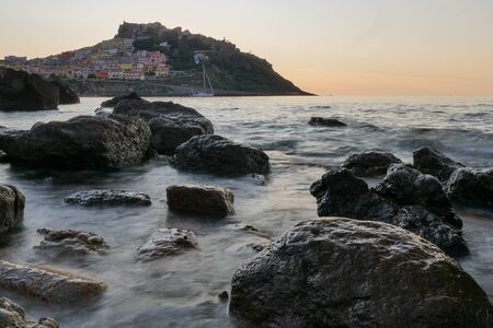 stones in the sea. coastline with village in the backの写真素材