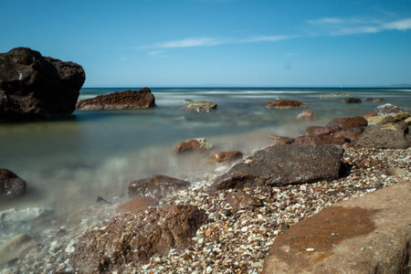 rocks in a sea with sunsetの写真素材