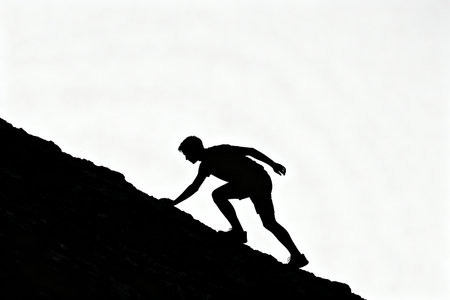 Silhouette of a man climbing up a mountain with white backgroundの素材