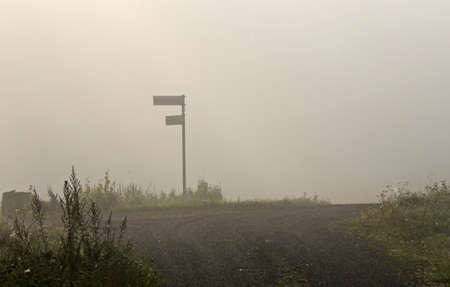Signpost at foggy crossroadsの写真素材
