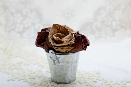 A small metallic bucket full of self made paper flowersの写真素材