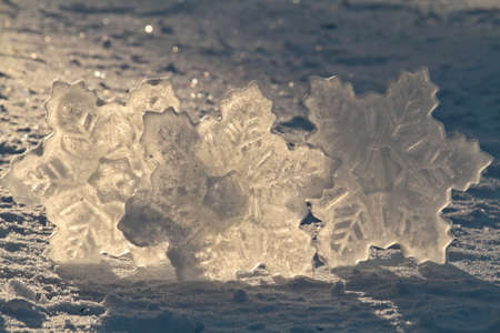Three snowflake figures frozen with a mold in the sunlight