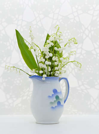 A bouquet of lily of the valley flowers in decorative ceramic potの写真素材