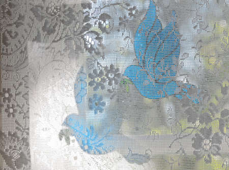 Blue glass bird by an old windowの写真素材