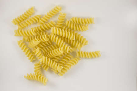 Uncooked Italian pasta, fusilli, on white backgroundの写真素材