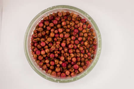 Pink rose pepper grain on white backgroundの写真素材