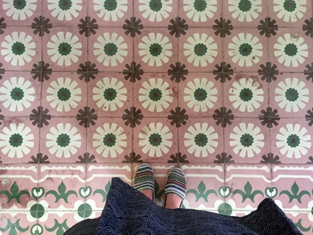 Feet over vintage tiled floorの写真素材