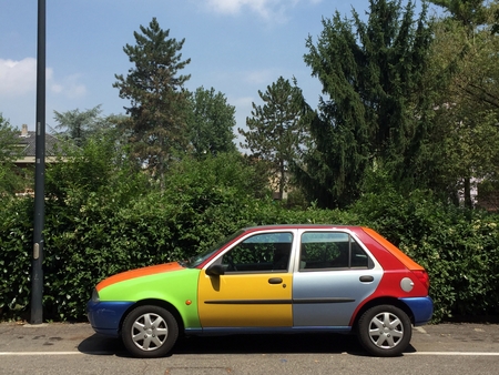 Multicolored car parked in city streetの写真素材