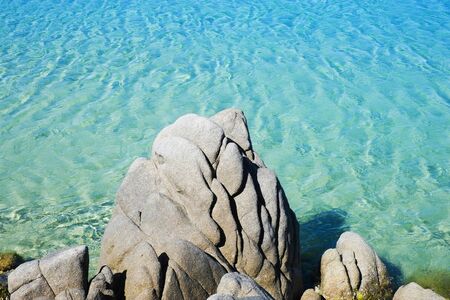 Transparent and green water with rock along the coast in Chia, Sardinia, Italyの写真素材