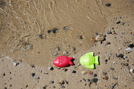 Plastic fishes on the seaside in a beach in Sardiniaの写真素材