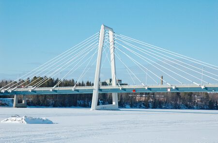 Modern bridge on the frozen river in Umea, north of Swedenの写真素材