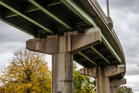 A closeup shot of a bridge under a cloudy sky in autumnの写真素材