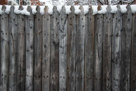Wooden fence in the snow. Winter background. Wooden fence.の写真素材