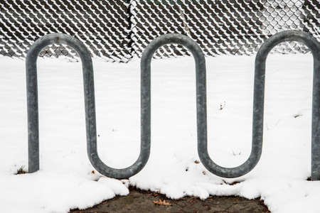 A close-up shot of a metal fence in the yard under the snowの写真素材