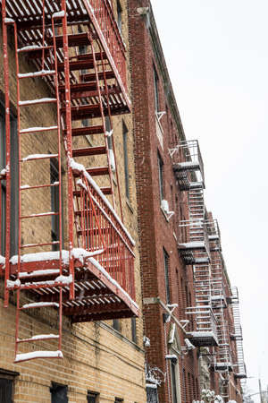 A low angle shot of a red fire escape on a brick wallの写真素材