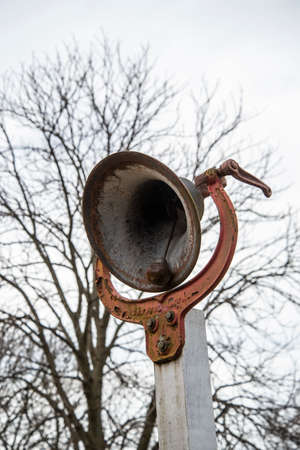 Old and rusty bullhorn on a pole against the background of treesの写真素材