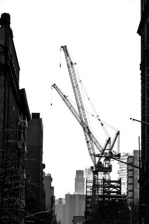 A black and white shot of a construction site with cranes.の写真素材