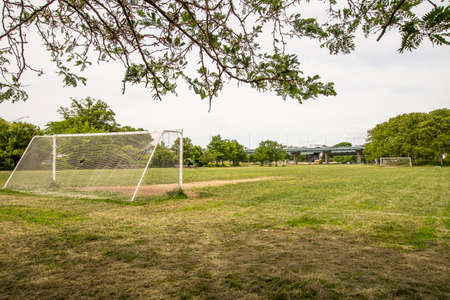 Soccer goal on green grass field with trees in the background.の写真素材