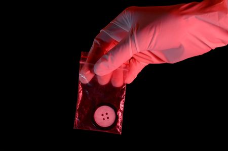 Hand in glove holding the evidence, isolated on black backgroundの写真素材