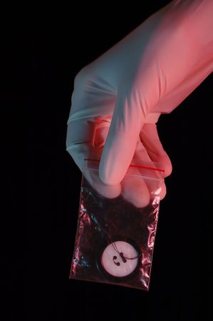 Hand in glove holding the evidence, isolated on black background
