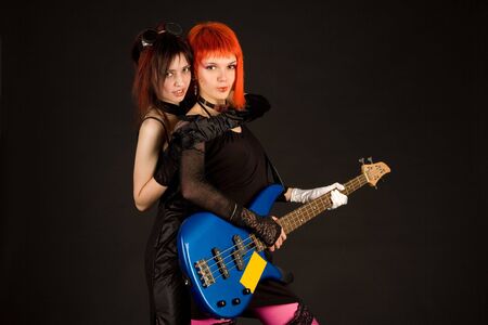 Two rock girls hugging isolated on black backgroundの写真素材