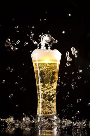 Beer glass with water splashes, isolated on black backgroundの写真素材