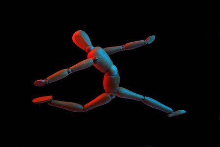 Flying wooden puppet, isolated on black background, red and blue light の写真素材