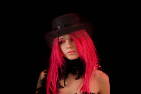 Upset girl with pink hair and make-up, isolated on black background の写真素材