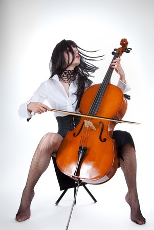 Sensual girl playing cello and moving her hair, studio shot の写真素材