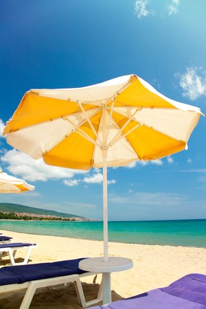 Bright umbrellas and chairs on beautiful tropical beach の写真素材