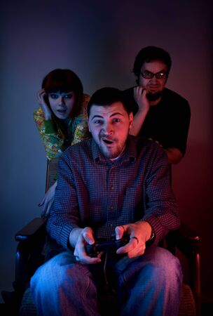 Young friends playing video games in front of tv or computer 