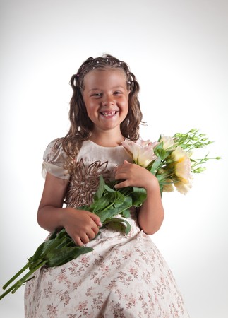 Cute little girl with pigtail hairstyle showing two missing teeth, studio shot  の写真素材
